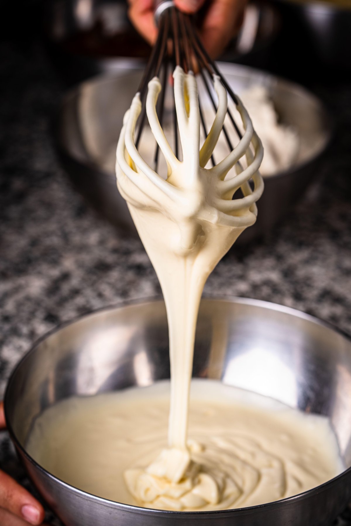 Whisk lifting cake batter from a mixing bowl in the Om Nom kitchen